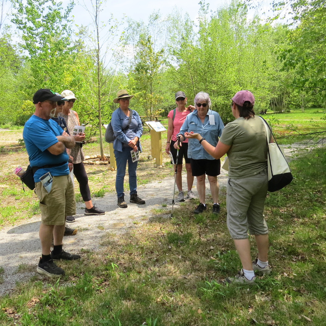 A group listens to a naturalist during a spring wildflower walk